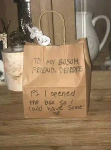 A brown paper bag with a lace ribbon tied to it. 