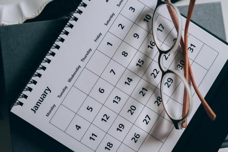 a calendar with a pair of glasses laying on top
