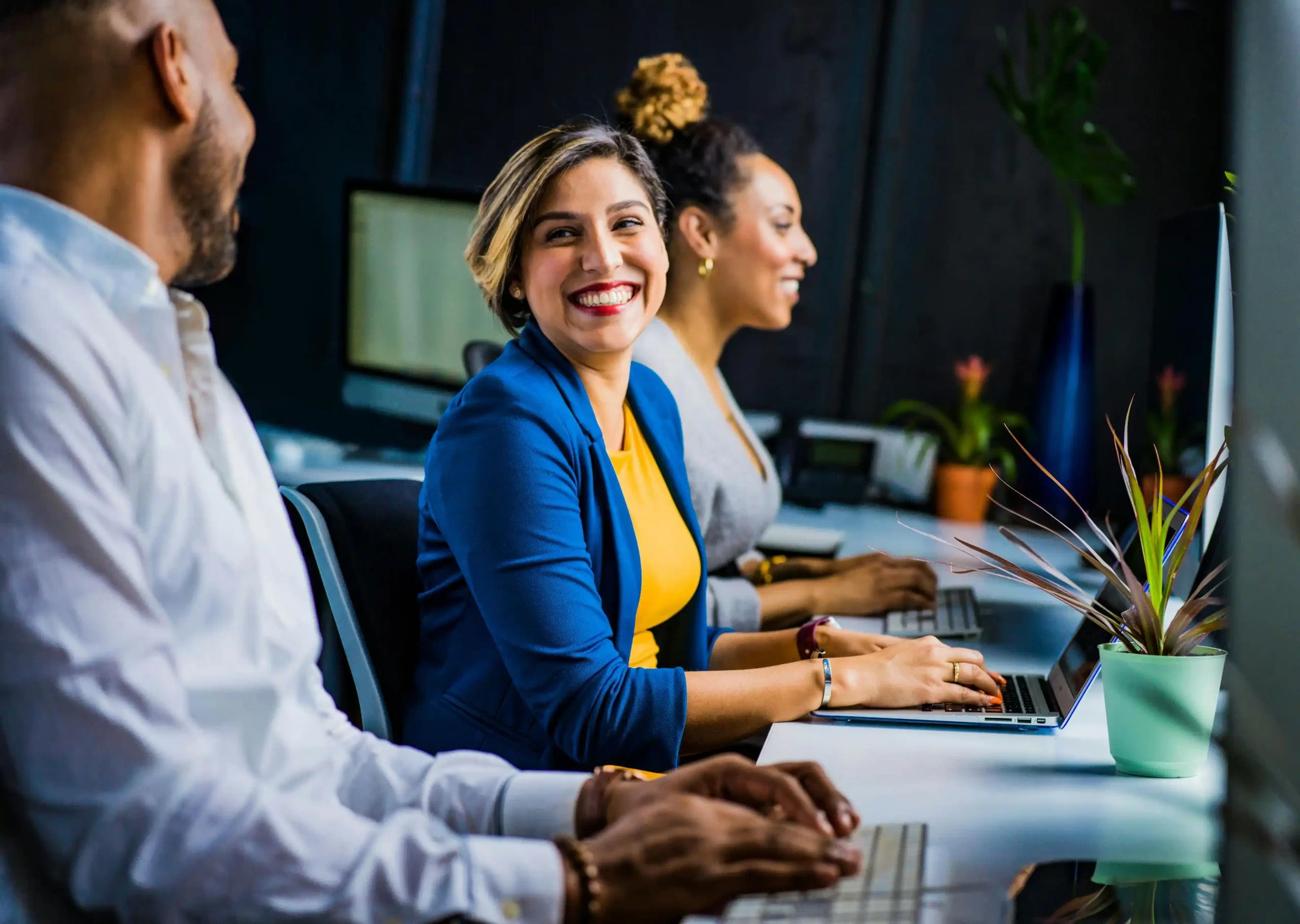 A smiling woman working in front of a laptop