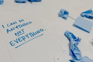 A piece of paper that says “I can do anything, but not everything” in blue marker.