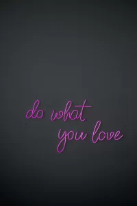 A black background with purple neon-like letters which read "do what you love" in cursive letters