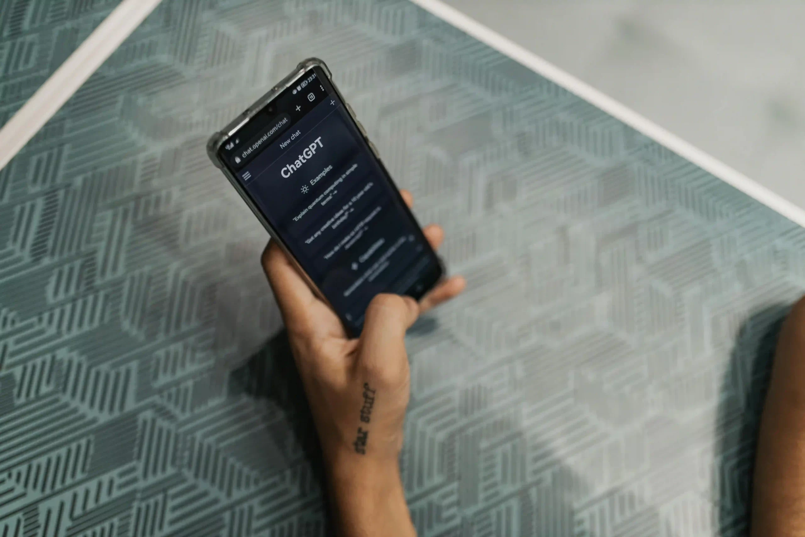 a person's hand holding a phone with chatgpt on the screen