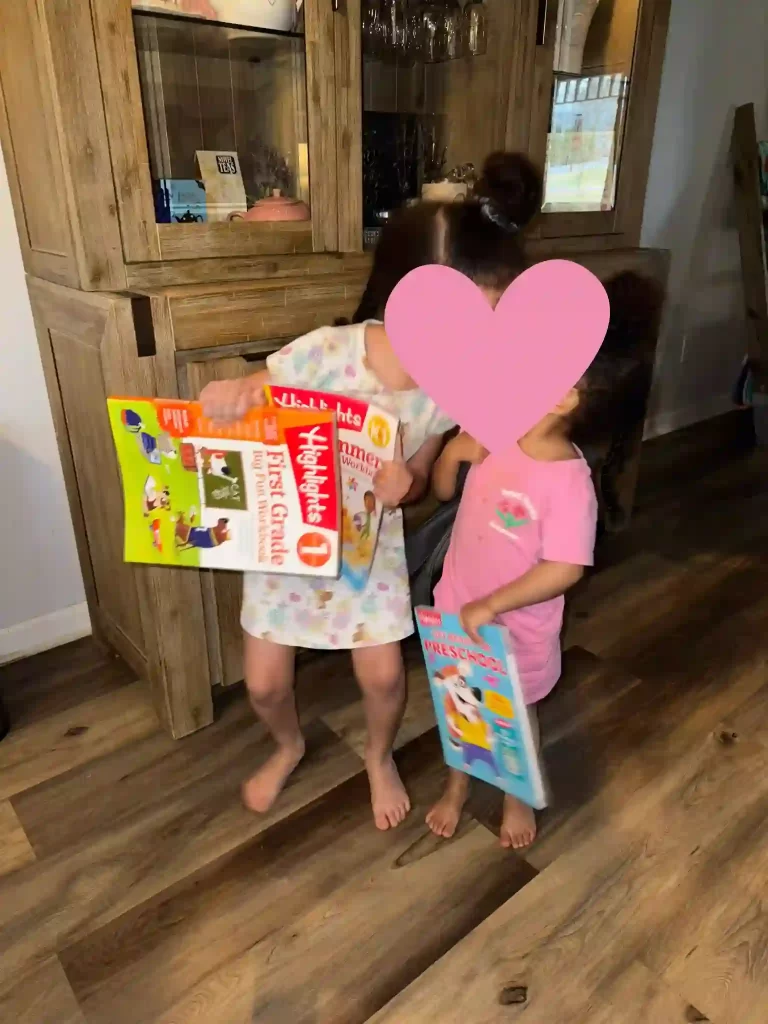 Two young girls holding Highlights workbooks