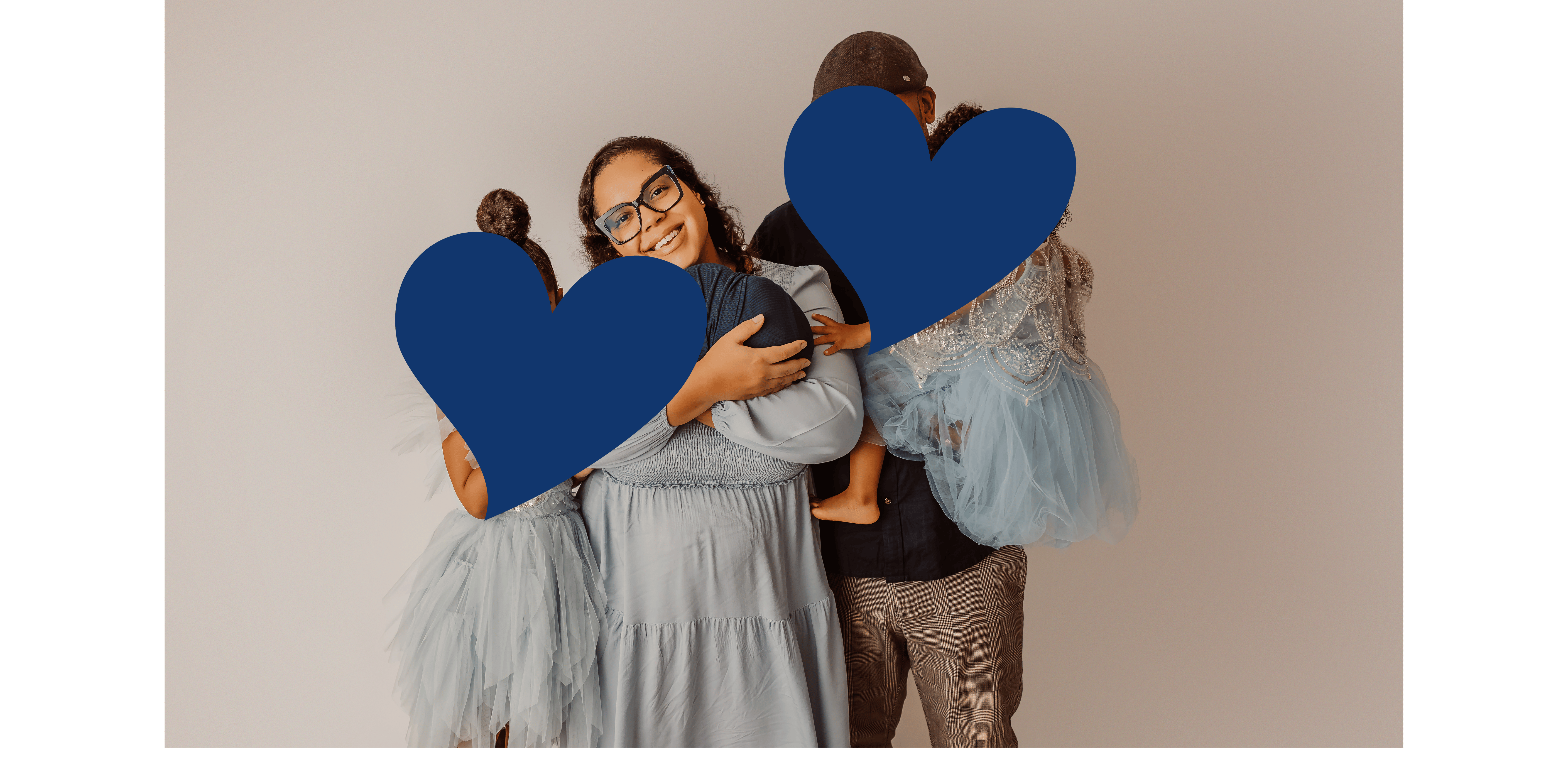 A family of five, with everyone's face covered with a blue heart, except for the mother's face.