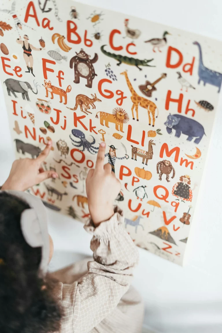 picture of a child's hands pointing to letter on an alphabet poster