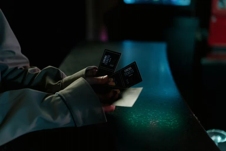a woman's hands holding two movie tickets