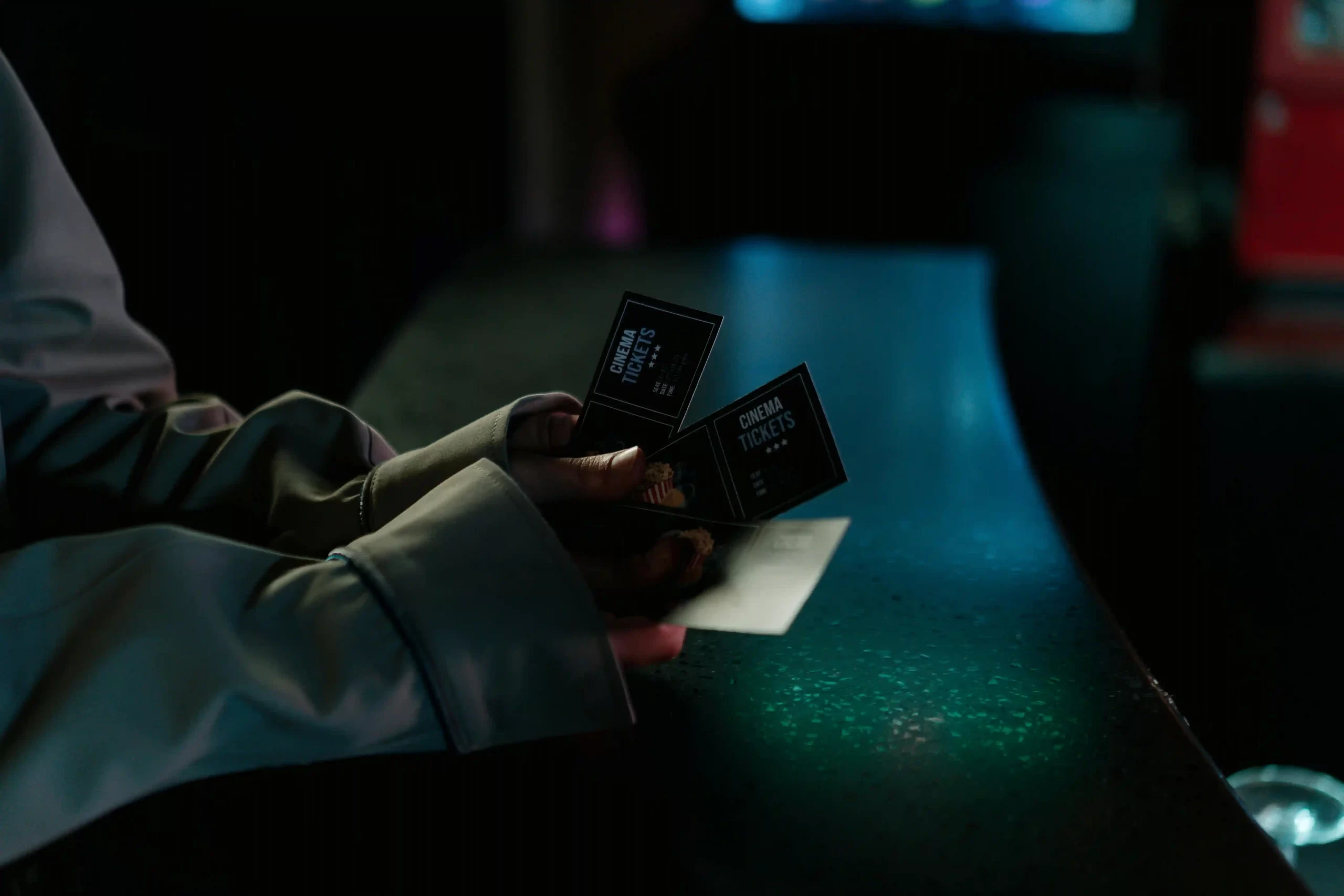 a woman's hands holding two movie tickets