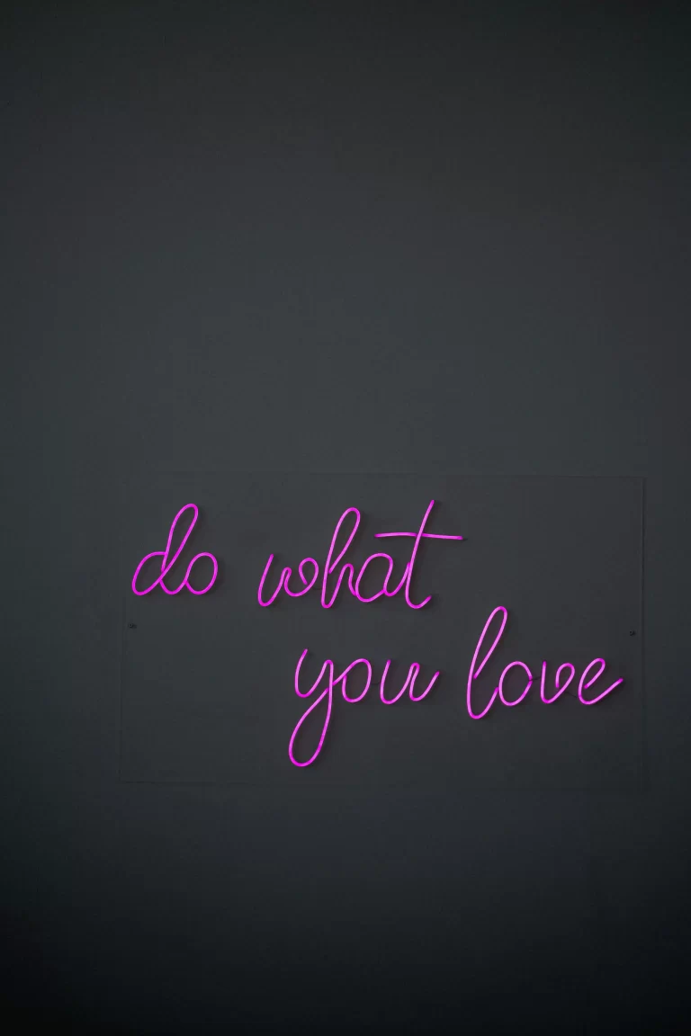A black background with purple neon-like letters which read "do what you love" in cursive letters