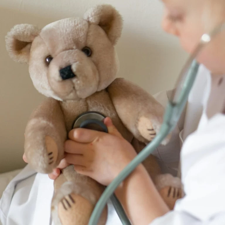 A child listening to a stuff bear's heart with a stethoscope