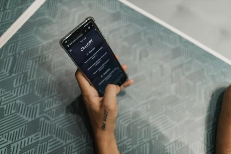 a person's hand holding a phone with chatgpt on the screen