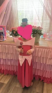 a child wearing a pink Sleeping Beauty dress