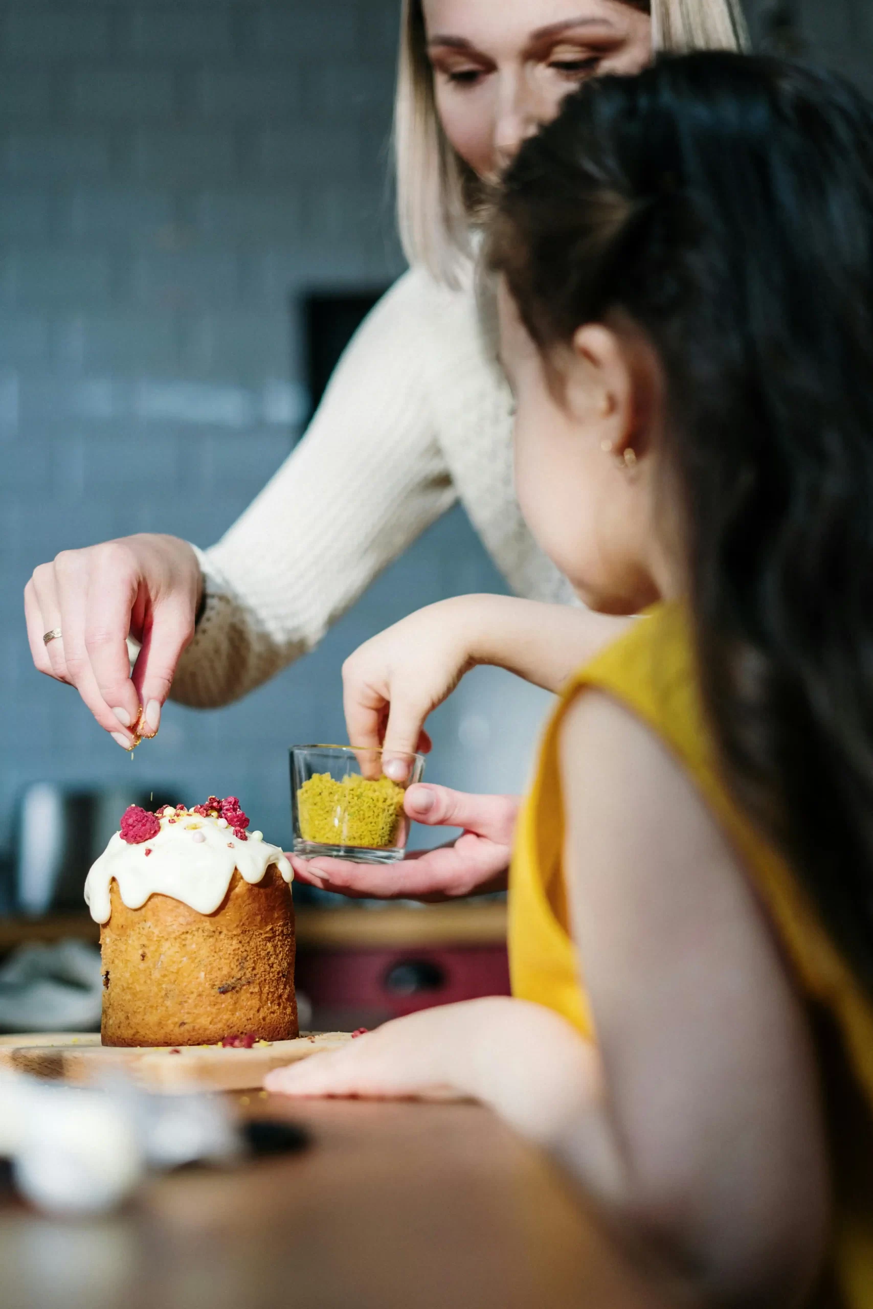A mother and daughter decorating a cake, representing baking activities to do with kids.