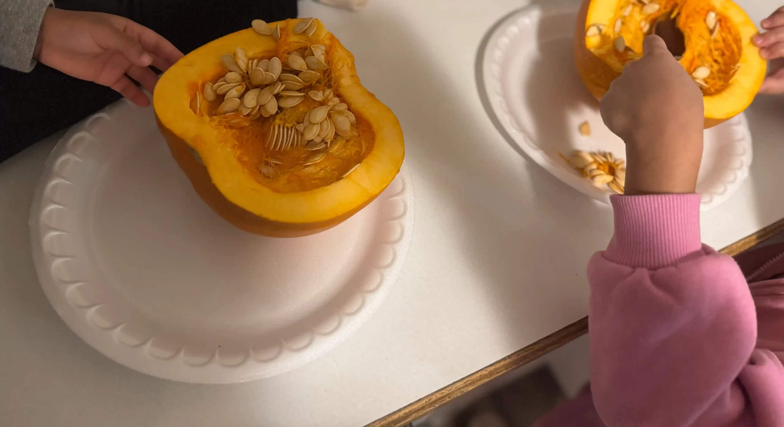 Young children scraping pumpkins, representing an easy fall recipe to try with kids