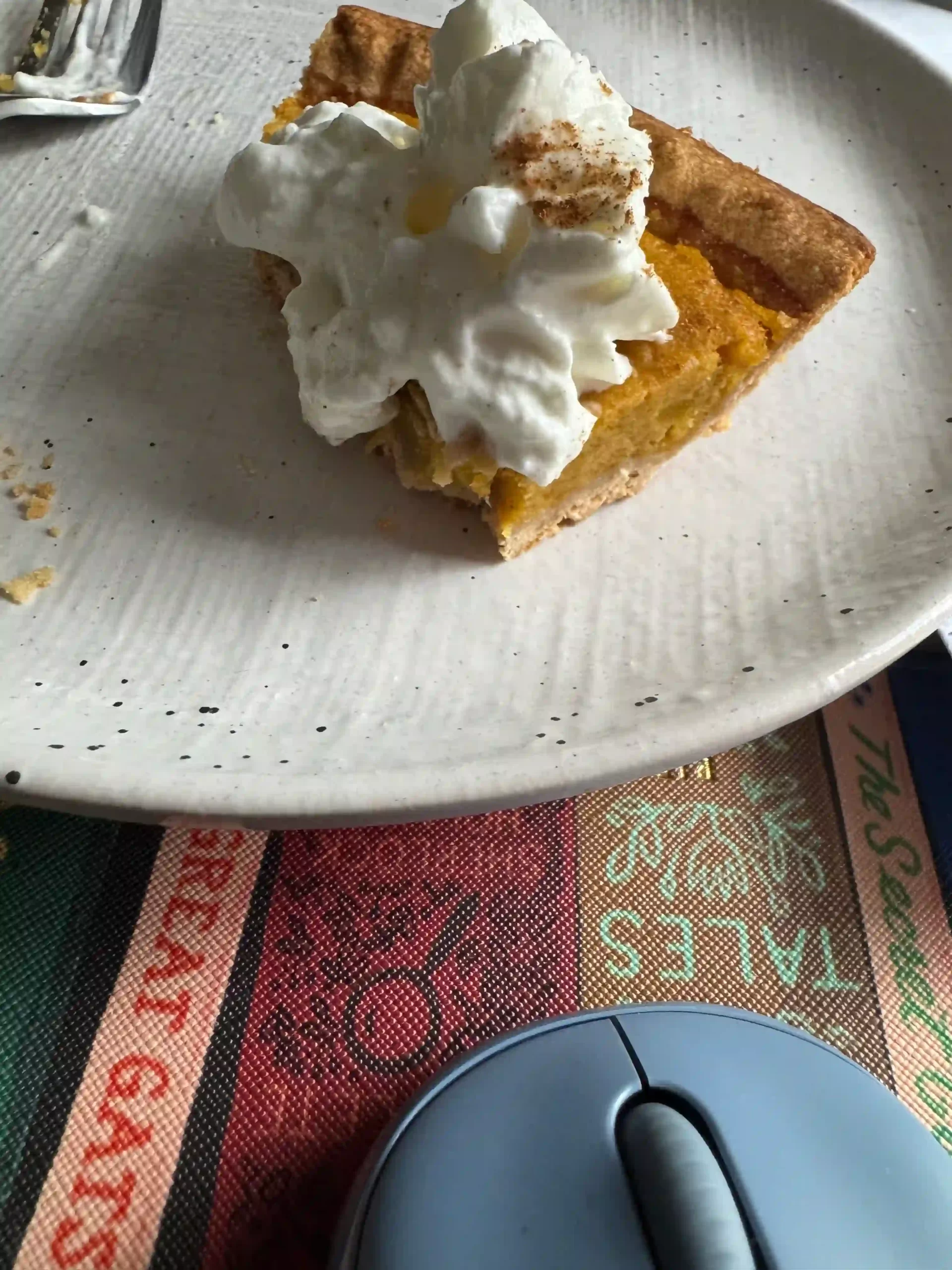 A half-eaten slice of pumpkin pie on a white plate representing a homemade pumpkin pie