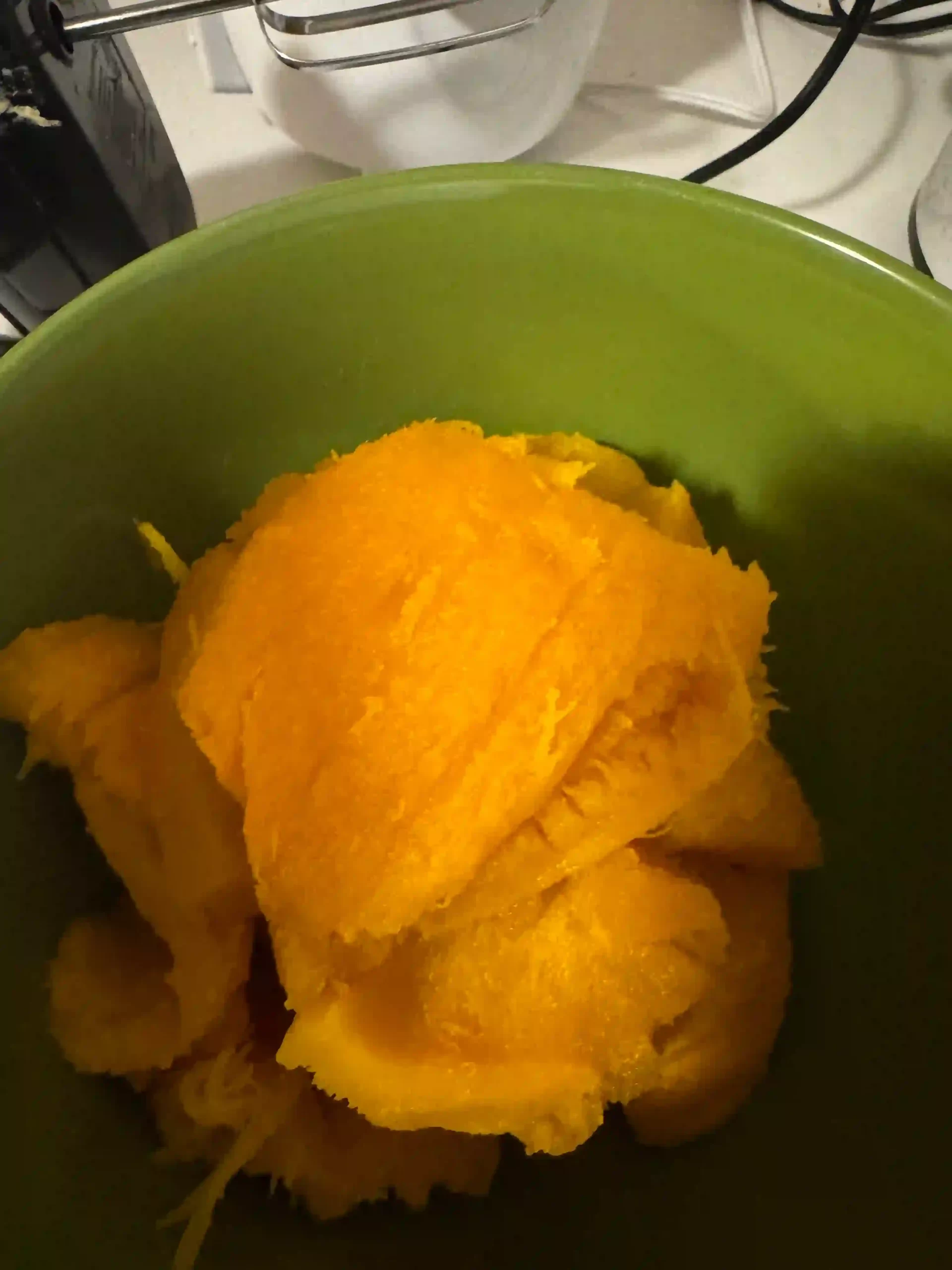A green bowl with freshly baked pie pumpkin