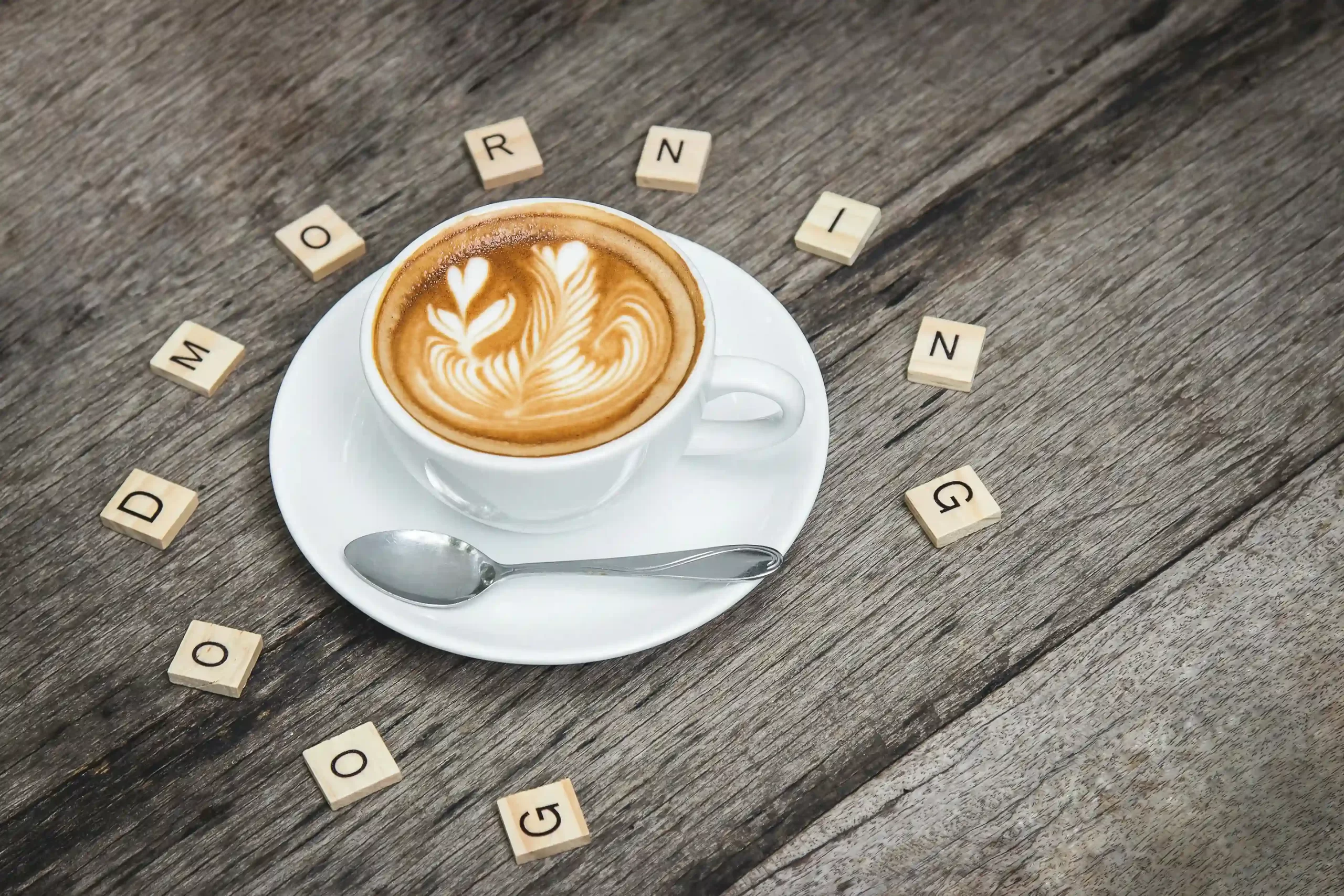 A cup of coffee surrounded by scrabble letters, spelling out "good morning", representing a purposeful homeschool morning routine homeschool