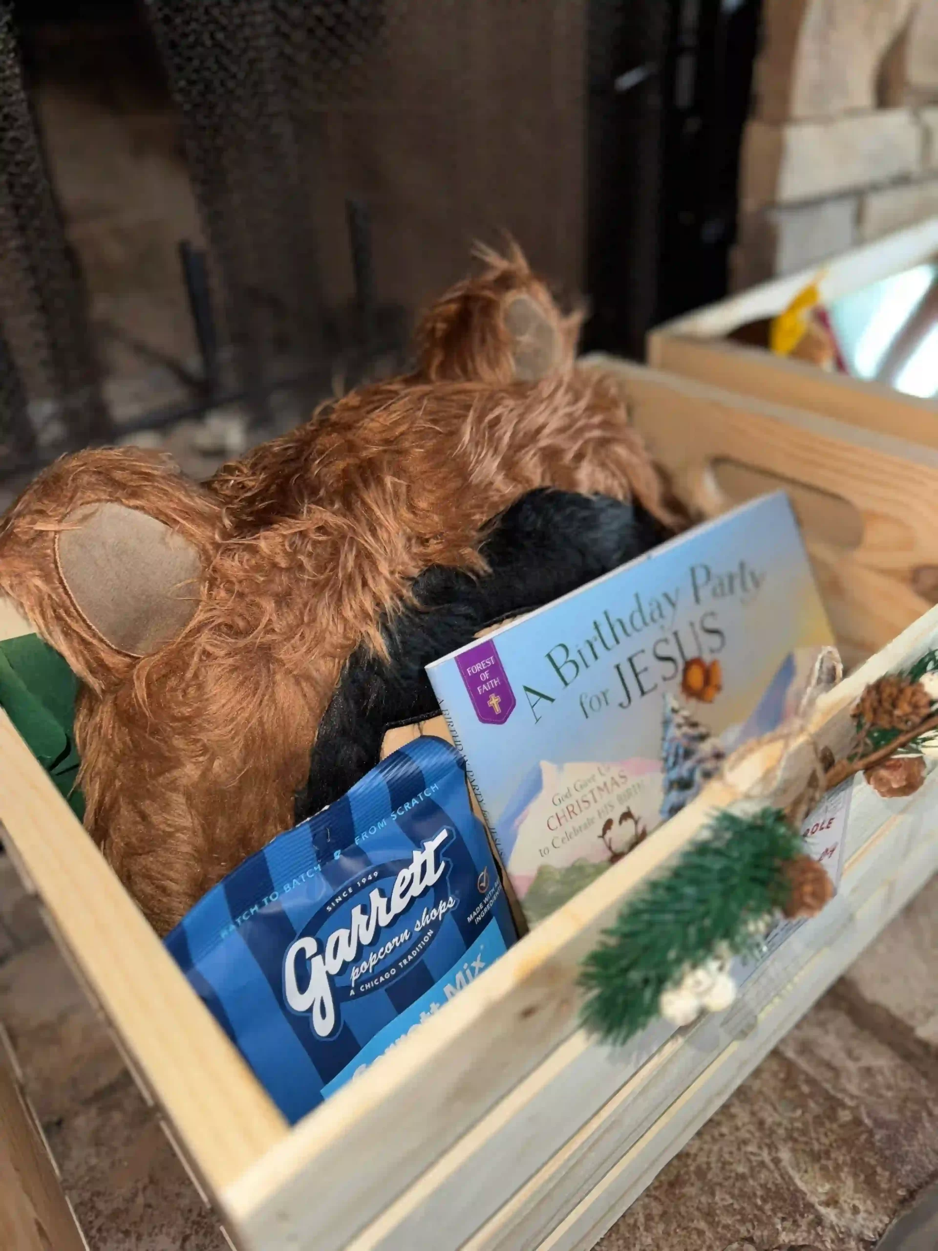 A wooden crate box with a book and animal-themed pillow, representing Christmas Eve box ideas.